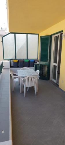 a patio with a table and benches on a balcony at CannetoMare in Canneto