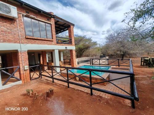 een huis met een zwembad ervoor bij Lion's Pride - Marloth Park in Marloth Park