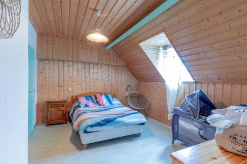- une chambre avec un lit dans un grenier en bois dans l'établissement Villa Bellevue avec piscine, à Agos-Vidalos