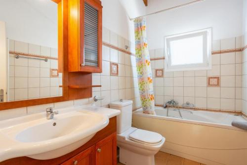 łazienka z umywalką, toaletą i wanną w obiekcie Villa Petros w mieście Katávolos