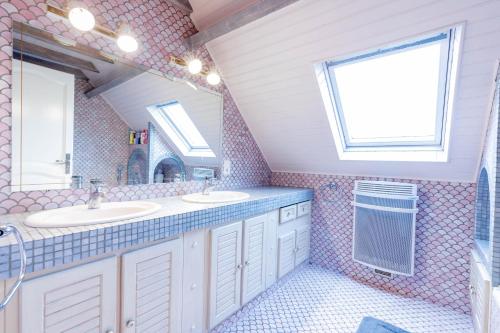 une salle de bain avec deux lavabos et une fenêtre dans l'établissement Villa Bellevue avec piscine, à Agos-Vidalos