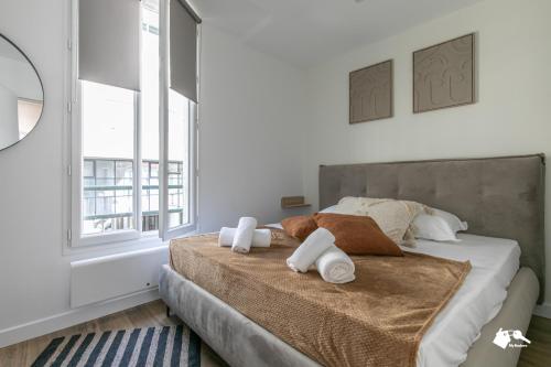 une chambre avec un lit avec des serviettes dessus dans l'établissement MBA - Diderot 3 - Splendide Appartement, à Montreuil