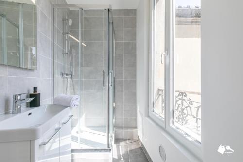 une salle de bain blanche avec une douche et un lavabo dans l'établissement MBA - Diderot 3 - Splendide Appartement, à Montreuil