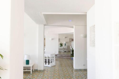 a hallway with white walls and flooring and a white staircase at Hotel Chiaia Di Luna in Ponza