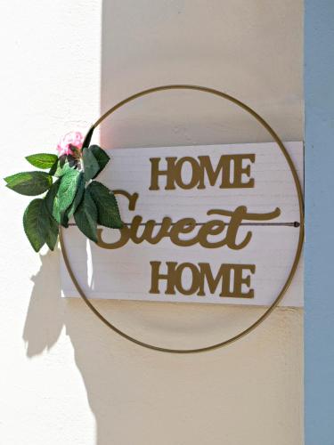 a sign that says home sweet home with a flower at Villa Lawton - Magnificent sea & mountain views! in Epáno Kefalás