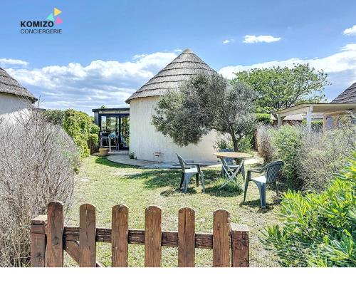 une cour avec une clôture, une table et des chaises dans l'établissement Villa Rivage, au Barcarès