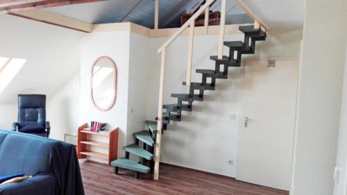 a staircase in a living room with a blue couch at Gelder Dyck in Kevelaer