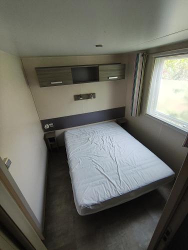 une petite chambre avec un lit et une fenêtre dans l'établissement Mobil-home bord de mer Hyères, à Hyères
