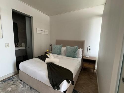 a bedroom with a large bed with blue pillows at Dante One Rosebank Apartment in Johannesburg