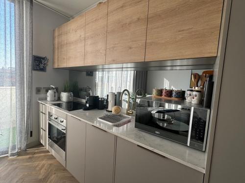 a kitchen with stainless steel appliances and wooden cabinets at Dante One Rosebank Apartment in Johannesburg