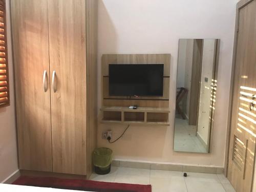 a living room with a television and a mirror at Homegate Resort in Araromi