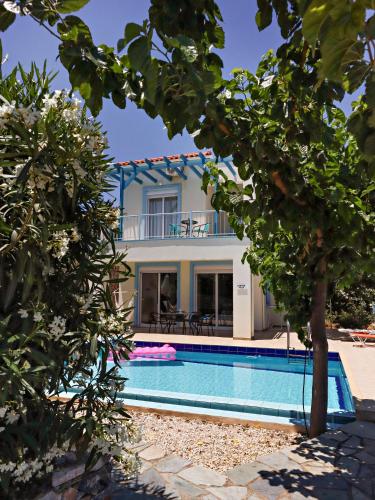 a villa with a swimming pool and a house at Villa Lawton - Magnificent sea & mountain views! in Epáno Kefalás