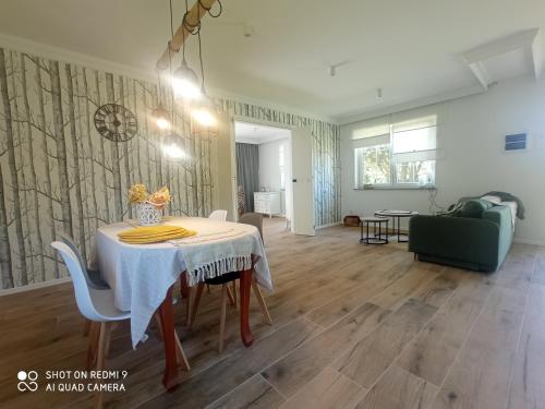 a dining room with a table and a living room at Agroturystyka Renatka 