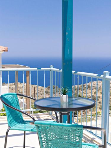 a table and chairs on a balcony with the ocean at Villa Lawton - Magnificent sea & mountain views! in Epáno Kefalás