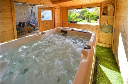 une baignoire jacuzzi dans une maison en bois dans l'établissement Velours 4 & Jacuzzi, à Saint-Nazaire