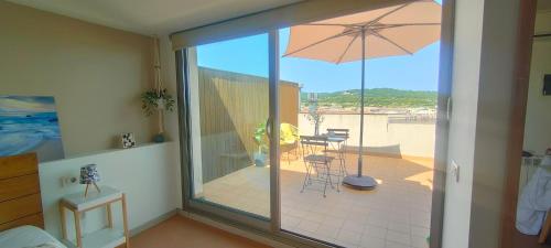 a balcony with an umbrella and a table and chairs at Apartamento Loft Mar&Pol in Palafrugell