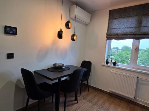 a dining room with a table and chairs and a window at DOMINO apartamentai, SELF CHECK-IN in Panevėžys