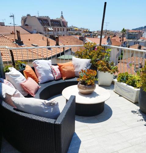 un patio avec des canapés et une table sur le toit dans l'établissement ROMANTIC LOFT WITH COSY TERRACE - Nice, à Nice
