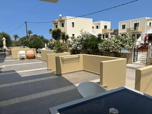 a view of a patio with chairs and buildings at Zephyros Village Maisonettes in Karpathos Town