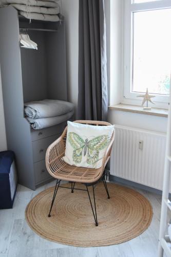 a butterfly pillow on a chair in a room at Apartment Promenadenkieken mit Pool in Dahme