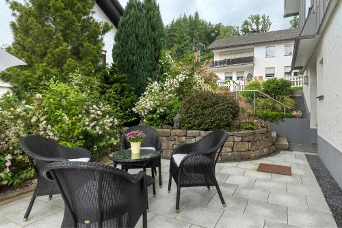 a patio with chairs and a table and a building at Schwalbennest in Lennestadt