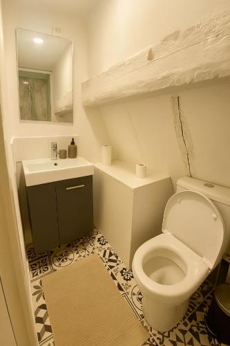 une salle de bain avec des toilettes blanches et un lavabo dans l'établissement PETIT HORLOGE, à Rouen