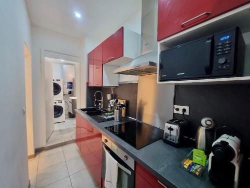 une cuisine avec un comptoir noir et un four micro-ondes dans l'établissement Monaco CARNIER Parking, à Beausoleil