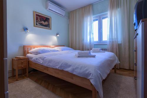 Schlafzimmer mit einem Bett mit weißer Bettwäsche und einem Fenster in der Unterkunft Holiday Villa Anna in Primorski Dolac
