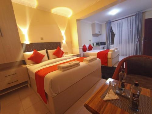 a hotel room with two beds and a table at Bijou Hotel in Nairobi