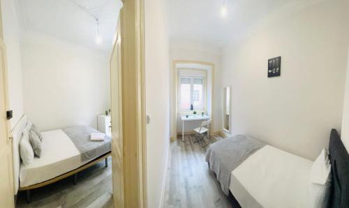 a room with two beds and a bathroom with a sink at High standard rooms Central Lisbon, super for tourists in Lisbon