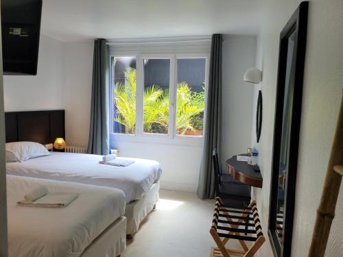 une chambre d'hôtel avec deux lits et une fenêtre dans l'établissement Hotel Duchesse Anne, à Dinan