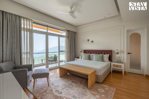 a bedroom with a bed and a large window at StayVista at The Ever House with Bonfire, Jacuzzi, Bathtub in Dharampur