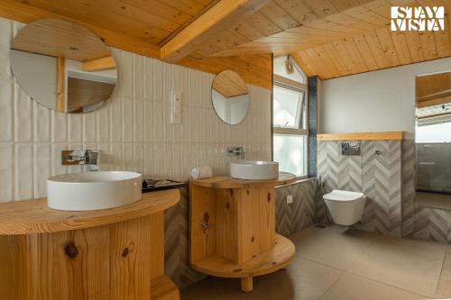 a bathroom with two sinks and a toilet at StayVista at The Ever House with Bonfire, Jacuzzi, Bathtub in Dharampur
