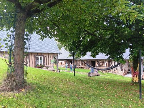 a park with a hammock in front of a building at Le Grenier in Saint-Christophe-sur-Condé