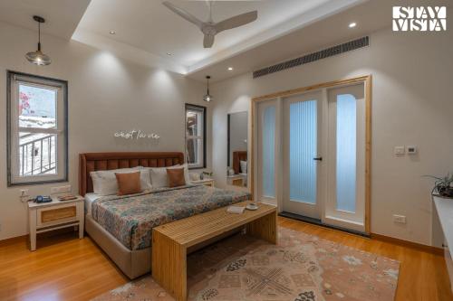 a bedroom with a bed and a table in it at StayVista at The Ever House with Bonfire, Jacuzzi, Bathtub in Dharampur