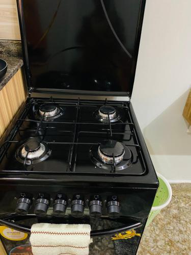 a black stove top oven in a kitchen at Cozy loft in Kampala