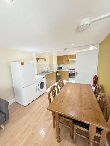 a kitchen and dining room with a wooden table at West Hampstead Hub! in London