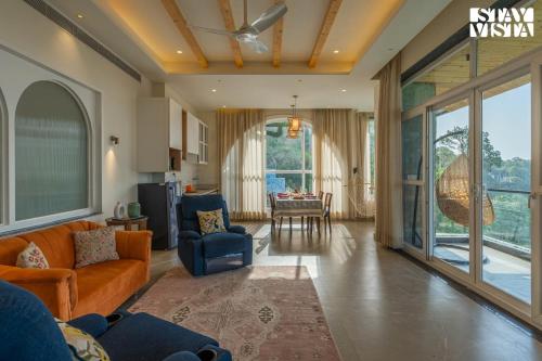 a living room with a couch and a dining room at StayVista at The Ever House with Bonfire, Jacuzzi, Bathtub in Dharampur