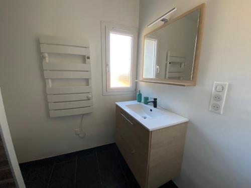 une salle de bain blanche avec un lavabo et un miroir dans l'établissement Le Narvick proche port-clim-wifi-parking, à La Ciotat