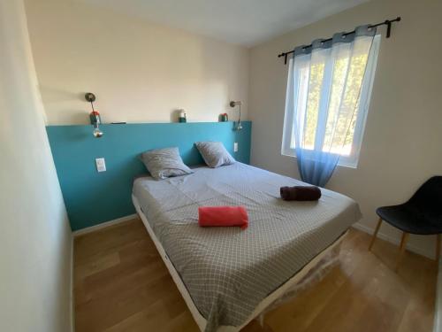 - un lit avec 2 oreillers rouges dans une chambre dans l'établissement Le Narvick proche port-clim-wifi-parking, à La Ciotat