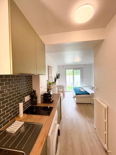 - une cuisine et un salon avec un canapé en arrière-plan dans l'établissement Le Cordouan, Terrasse Extérieure, Royan, à Royan