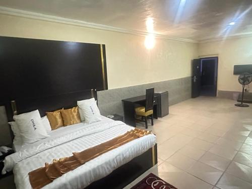 a hotel room with a large bed and a desk at Daniel's Hotel & Apartment in Mama