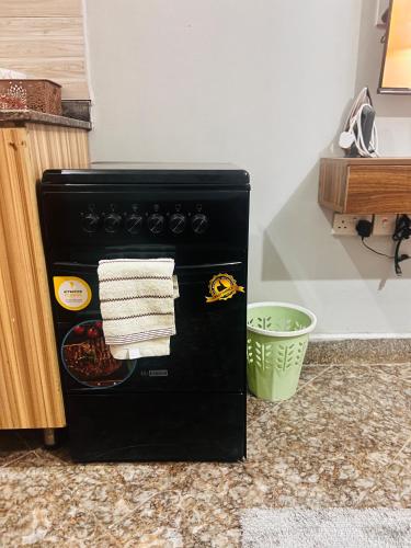 a black stove in a kitchen with towels on it at Cozy loft in Kampala