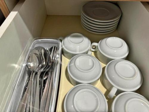 a drawer filled with white dishes and silver utensils at Rex apartment Kuching 3 pax in Kuching