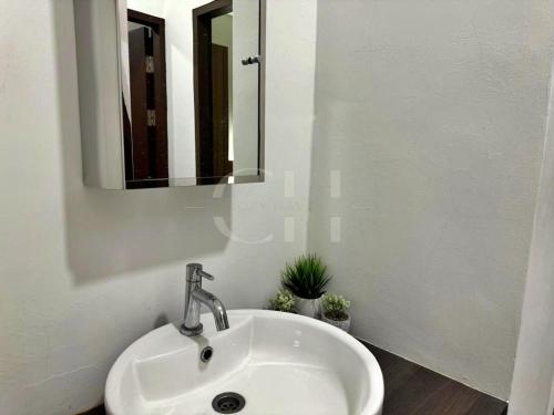 a white sink in a bathroom with a mirror at Rex apartment Kuching 3 pax in Kuching