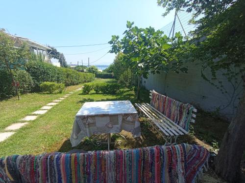 a table and a bench in a yard at Wooden Summer House in Mantoúkion