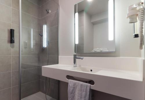 a bathroom with a sink and a shower at B&B HOTEL Le Creusot Montchanin in Montchanin