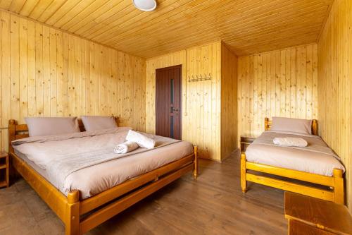 a bedroom with two beds in a wooden room at Dana NEW 2025 in Solotvyno