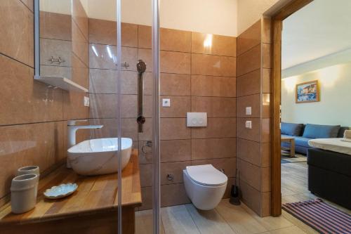a bathroom with a toilet and a glass shower at Rooms by the sea Sutivan, Brac - 24402 in Sutivan
