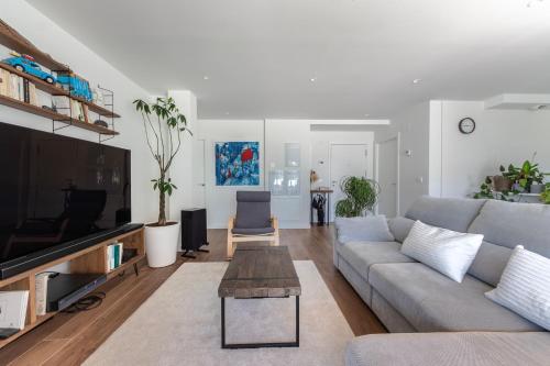 a living room with a couch and a tv at Aston - Sopela relajante cerca de la playa in Bareño